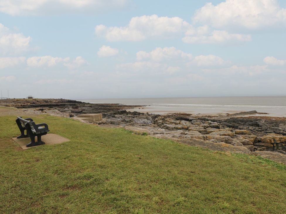An outdoor area with a bench overlooking the sea at Ty Traeth in Porthcawl