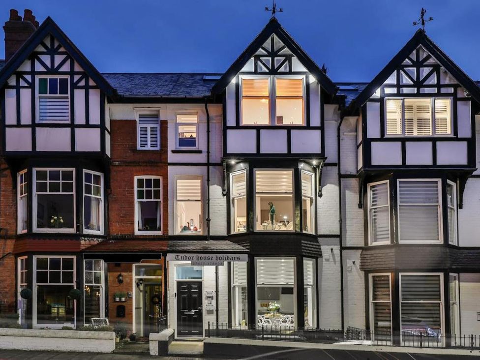 A house with multiple windows and a sign at Tudor House Holidays in Scarborough