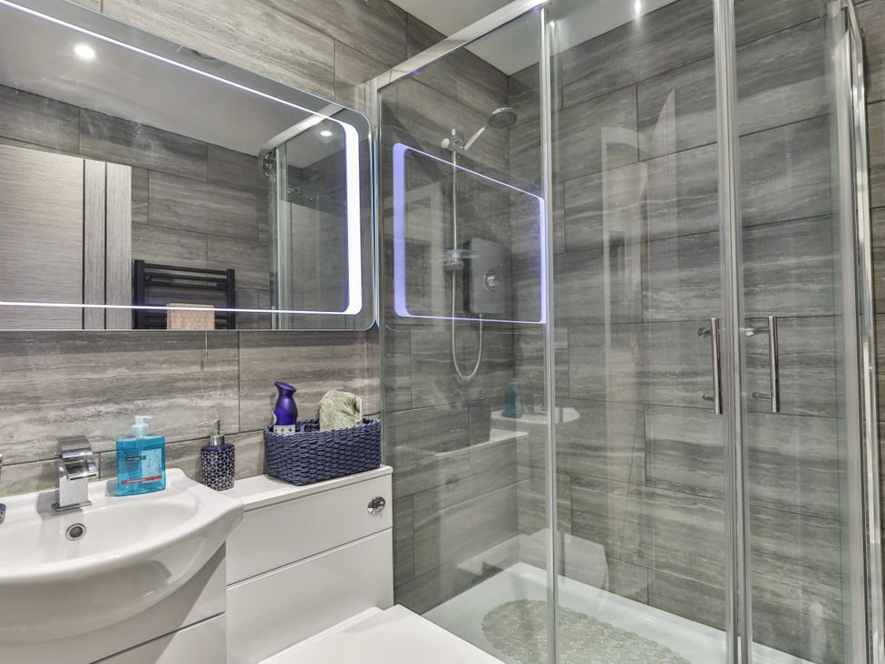 A bathroom with shower, sink, and toiletries at 1 Bed Flat - Sleeps 2 - Parking - Wifi, Scarborough