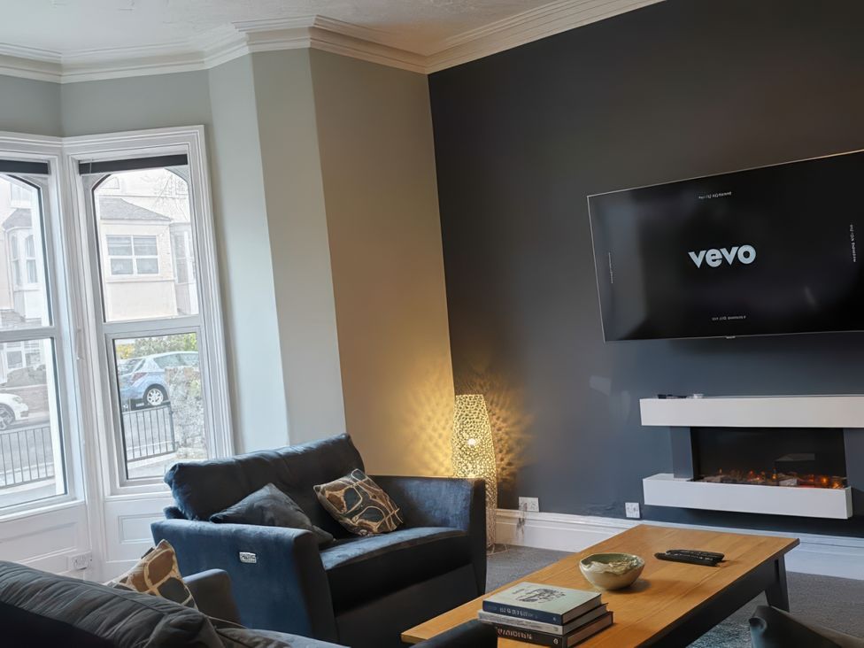 A living room with a television and sofa at Holiday home guest house in Llandudno