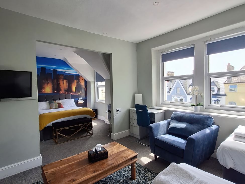 A bedroom with a bed and seating area at Holiday home guest house in Llandudno