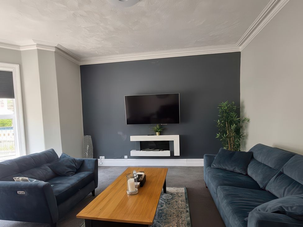 A living room with a television and coffee table at Holiday home guest house, Llandudno