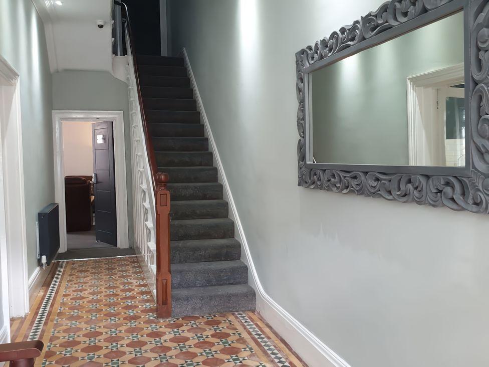 A hallway with a staircase and a mirror at Holiday home guest house Llandudno