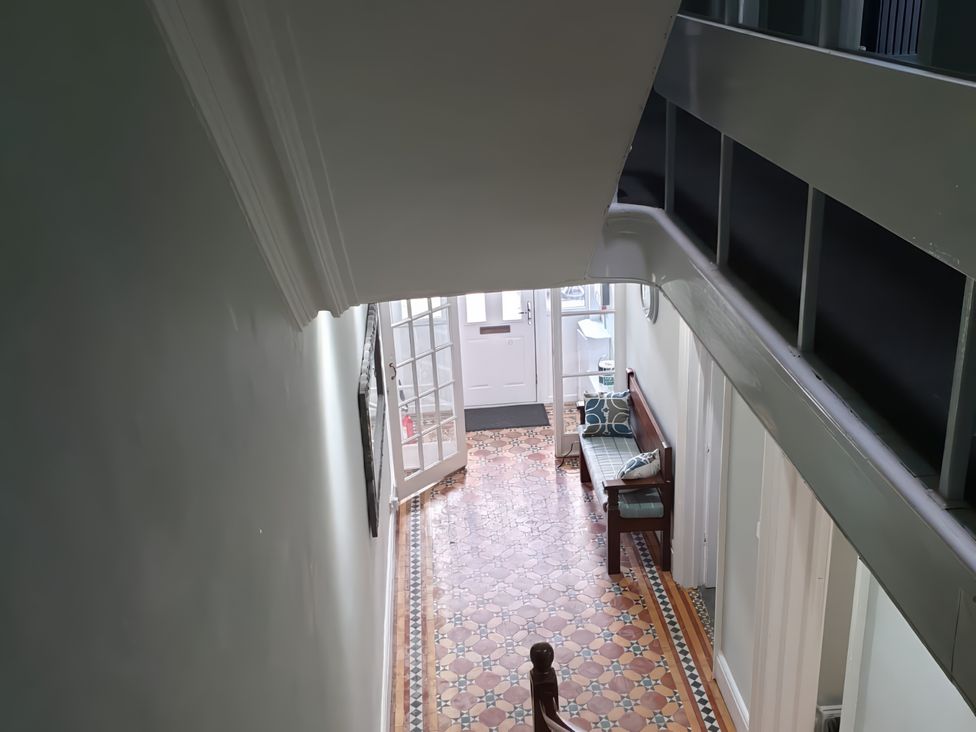 A hallway with a staircase and bench at Holiday home guest house Llandudno