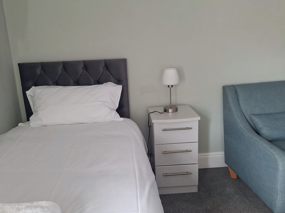 A bedroom with a single bed and a nightstand at Holiday home guest house in Llandudno