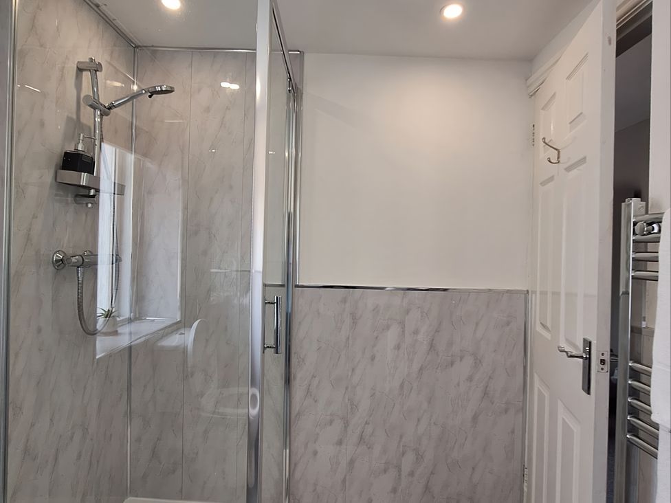 A bathroom with a shower and towel rail at Holiday home guest house in Llandudno