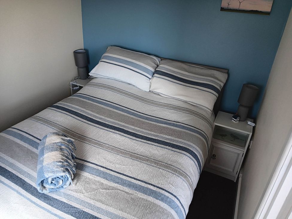 A bedroom with a bed and bedside table at Bay View Chalet 2 Bed Sleeps 4 Pets Garden Beach Wilsthorpe near Bridlington