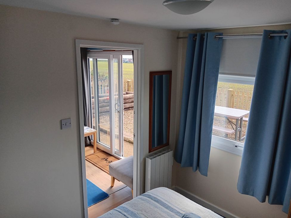 A bedroom with a bed and mirror at Bay View Chalet 2 Bed Sleeps 4 Pets Garden Beach in Wilsthorpe near Bridlington