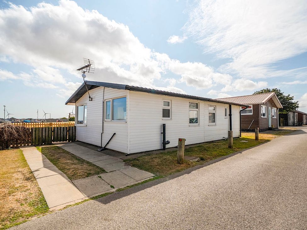 A house with windows beside a pathway at Bay View Chalet 2 Bed Sleeps 4 Pets Garden Beach Wilsthorpe near Bridlington