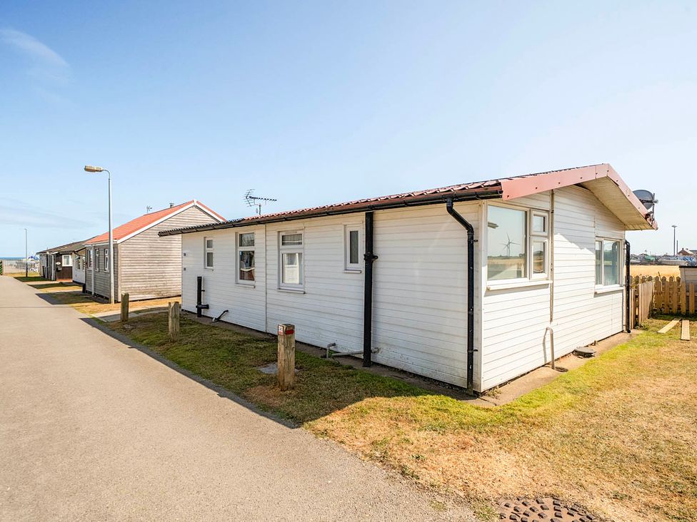 An outdoor area with a white house and pathway at Bay View Chalet 2 Bed Sleeps 4 Pets Garden Beach Wilsthorpe near Bridlington