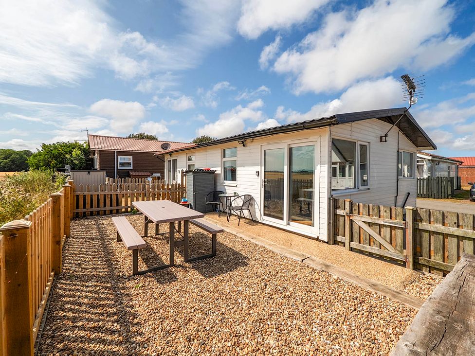An outdoor area with a table and chairs at Bay View Chalet 2 Bed Sleeps 4 Pets Garden Beach Wilsthorpe near Bridlington