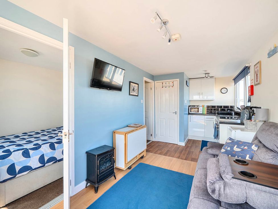A living room with a bed and kitchen area at Bay View Chalet 2 Bed Sleeps 4 Pets Garden Beach Wilsthorpe near Bridlington