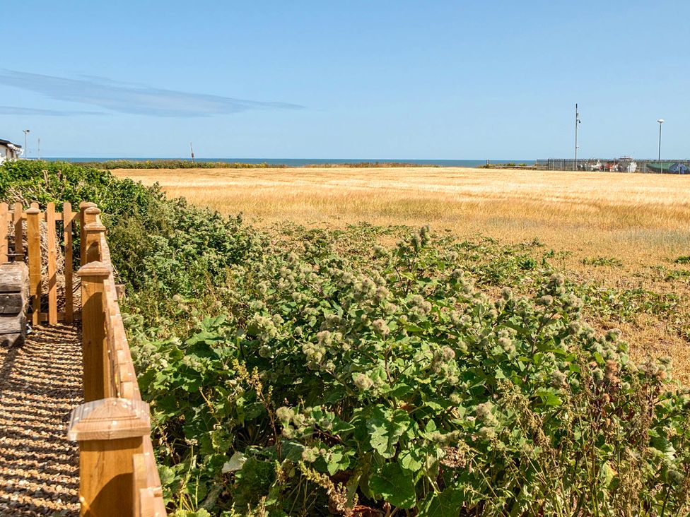 A view of an ocean and field with a fence at Bay View Chalet 2 Bed Sleeps 4 Pets Garden Beach Wilsthorpe near Bridlington