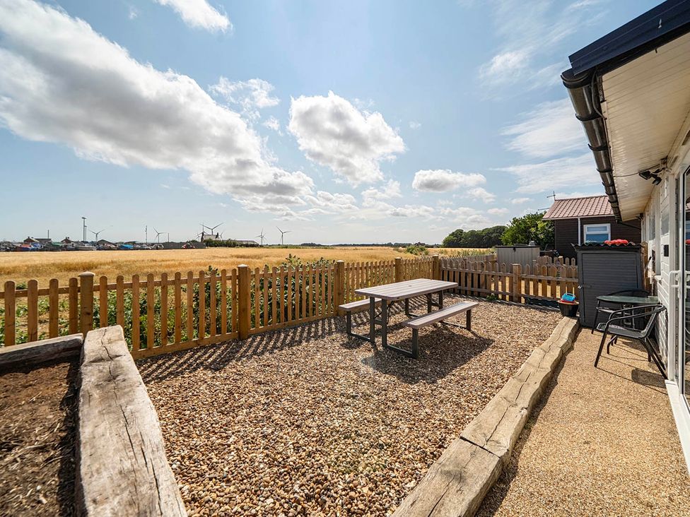 A garden with a table and chairs at Bay View Chalet 2 Bed Sleeps 4 Pets Garden Beach Wilsthorpe near Bridlington