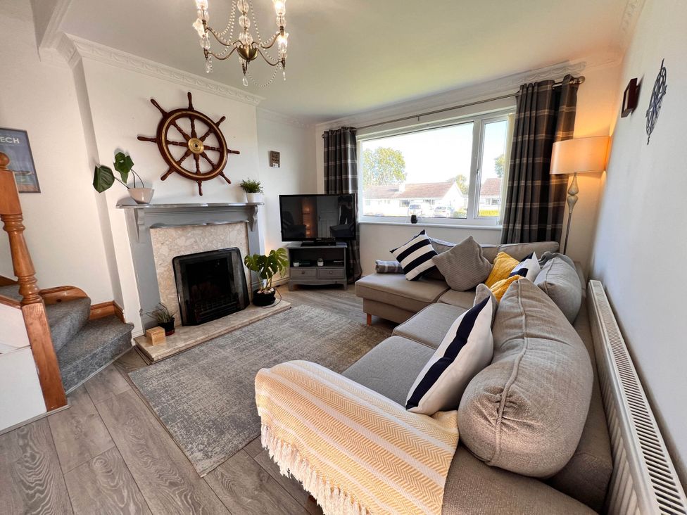 A living room with a sofa and television at 2 Bed Family Bungalow, WiFi, Parking, Garden, Dogs Pentraeth