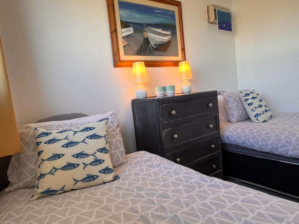 A bedroom with two beds and a dresser at 2 Bed Family Bungalow, WiFi, Parking, Garden, Dogs, Pentraeth