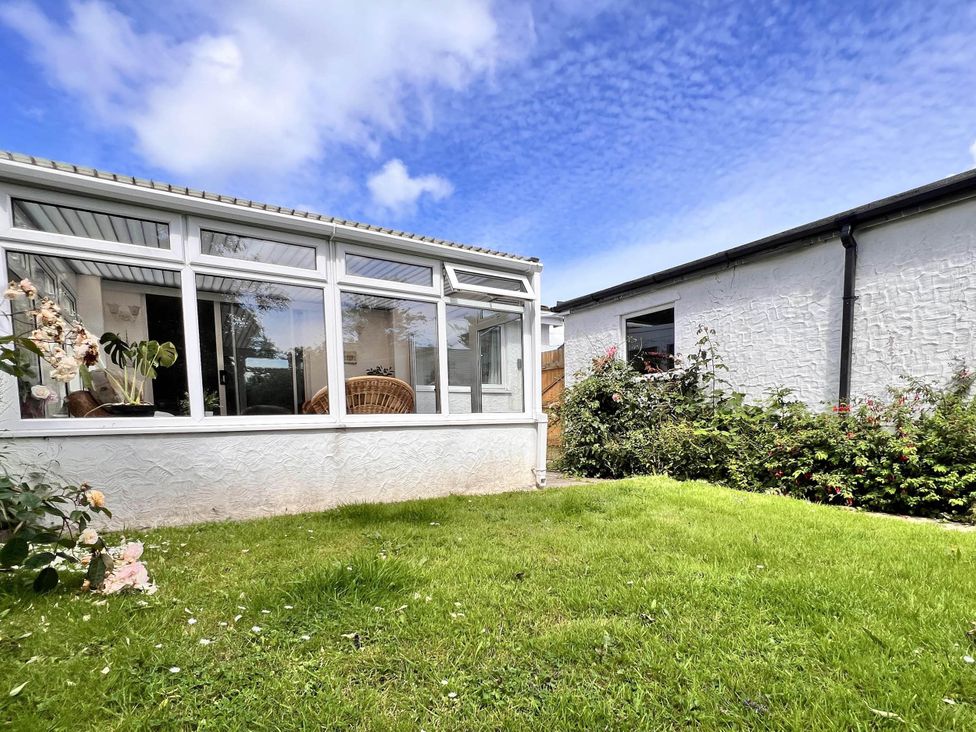 A conservatory attached to a house with a garden at 2 Bed Family Bungalow, WiFi, Parking, Garden, Dogs in Pentraeth