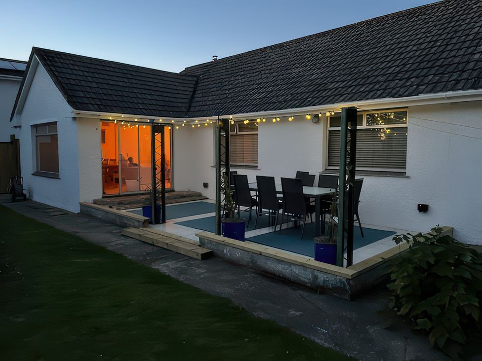 An outdoor patio with seating and table at Sleeps 9 KingBeds Family Friendly, Pityme near Penmayne