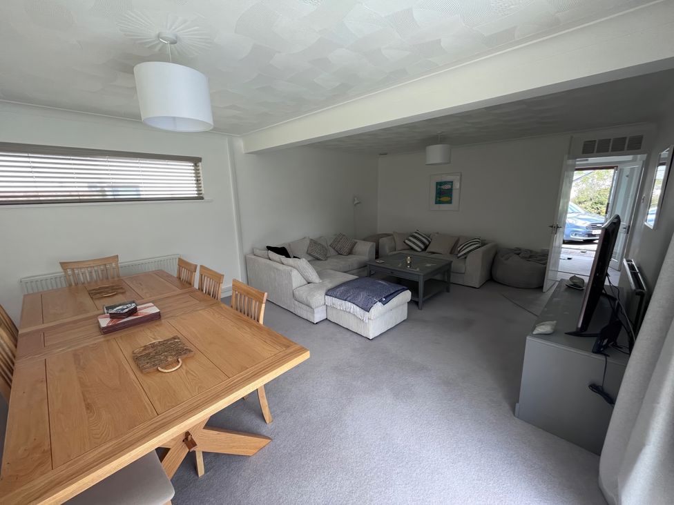 A living room with a dining table and sofa at Sleeps 9 KingBeds Family Friendly, Pityme near Penmayne