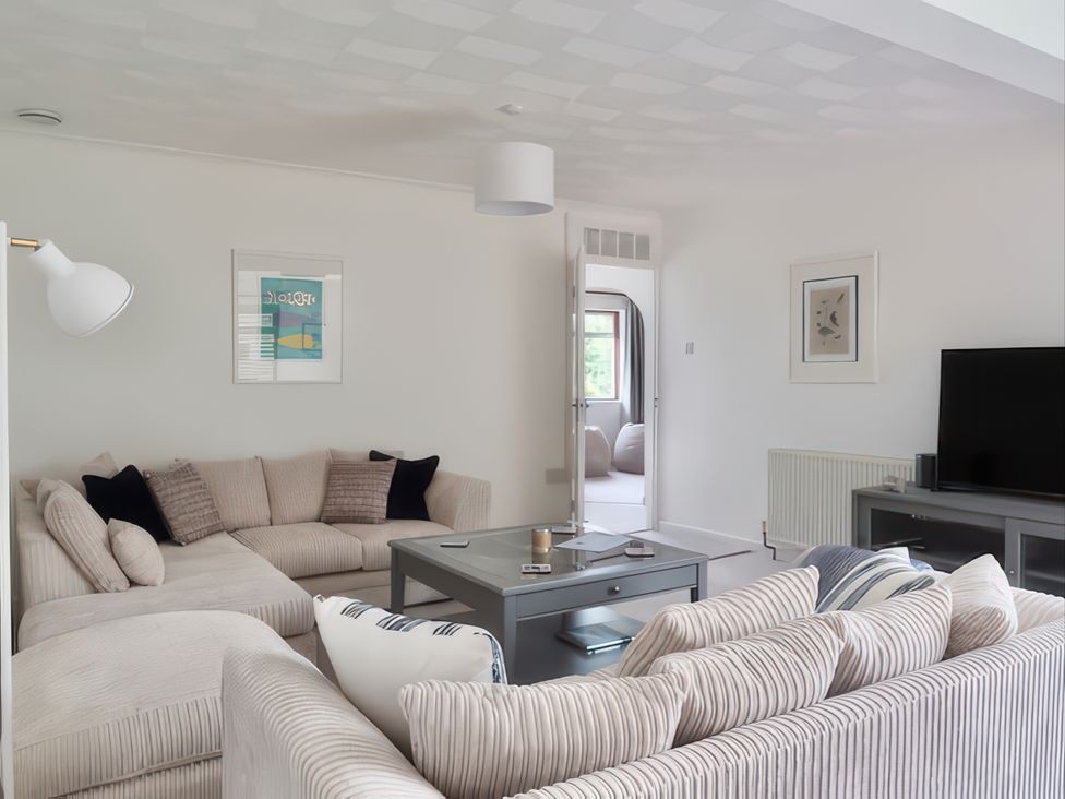 A living room with a sofa and TV at Sleeps 9 KingBeds Family Friendly in Pityme near Penmayne
