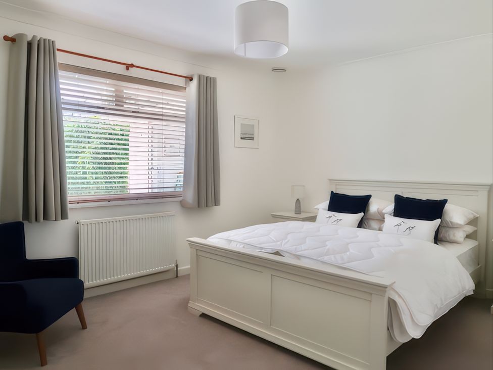 A bedroom with a bed and an armchair at Sleeps 9 KingBeds Family Friendly in Pityme near Penmayne