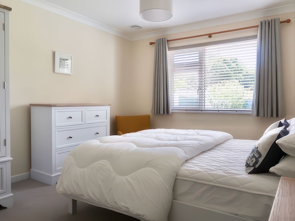 A bedroom with a bed and dresser at Sleeps 9 KingBeds Family Friendly, Pityme near Penmayne