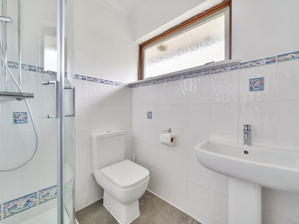 A bathroom with a shower, toilet, and sink at Sleeps 9 KingBeds Family Friendly Pityme near Penmayne