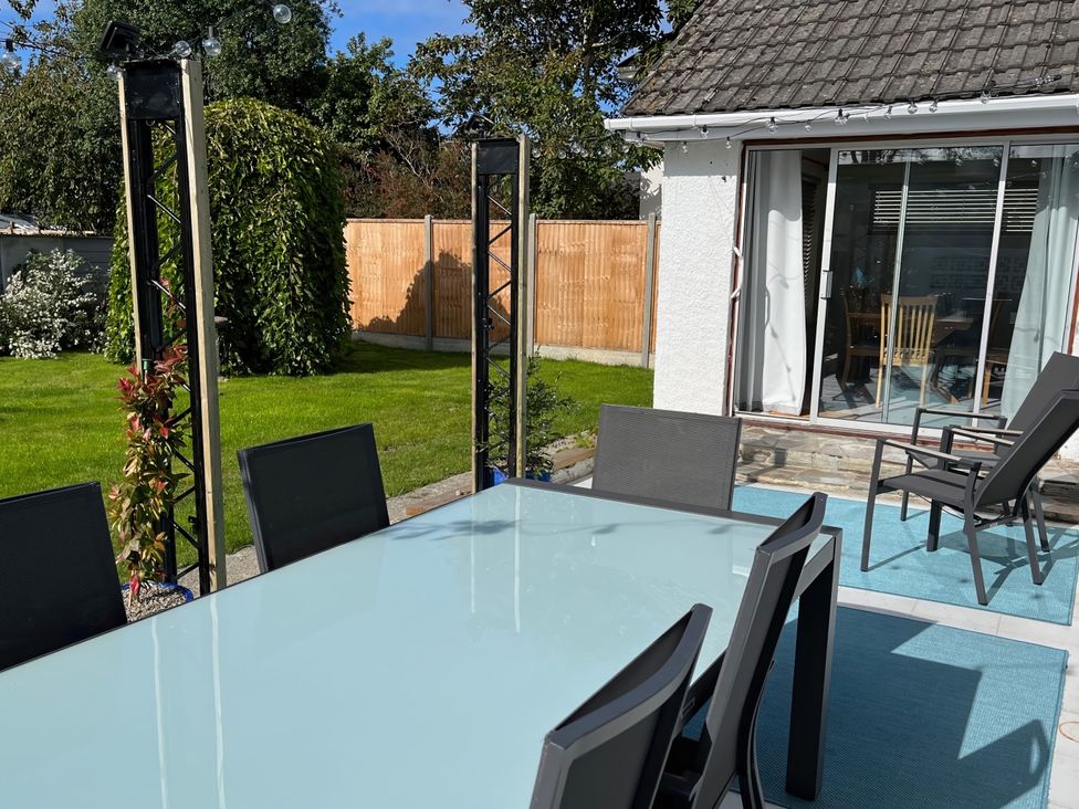 A garden with a table and chairs at Sleeps 9 KingBeds Family Friendly in Pityme near Penmayne