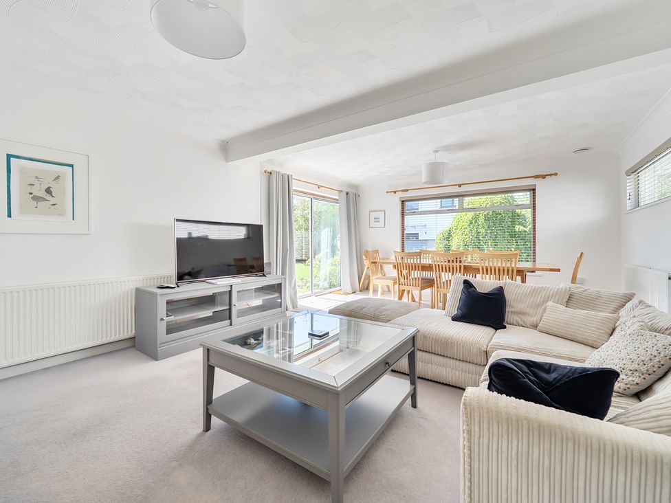 A living room with a sofa and dining area at Sleeps 9 KingBeds Family Friendly in Pityme near Penmayne