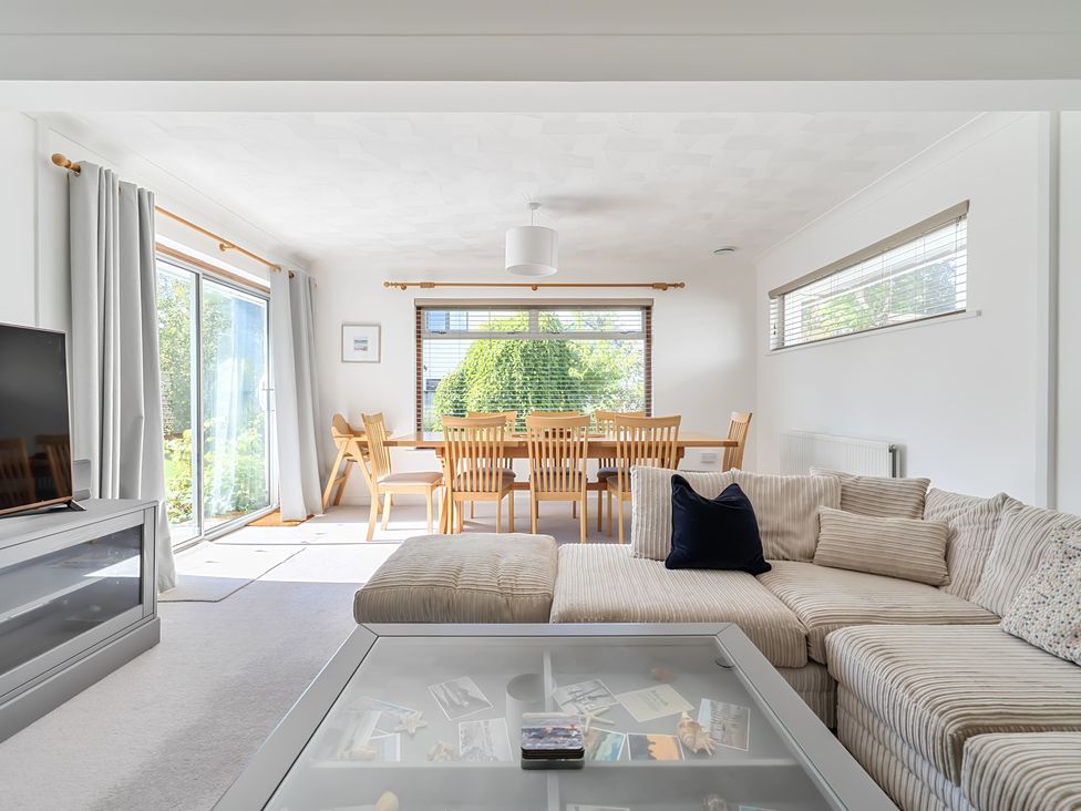 A dining room with a sofa and television at Sleeps 9 KingBeds Family Friendly Pityme near Penmayne