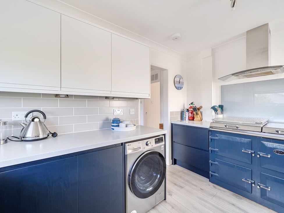 A kitchen with a washing machine and kettle at Sleeps 9 KingBeds Family Friendly in Pityme near Penmayne