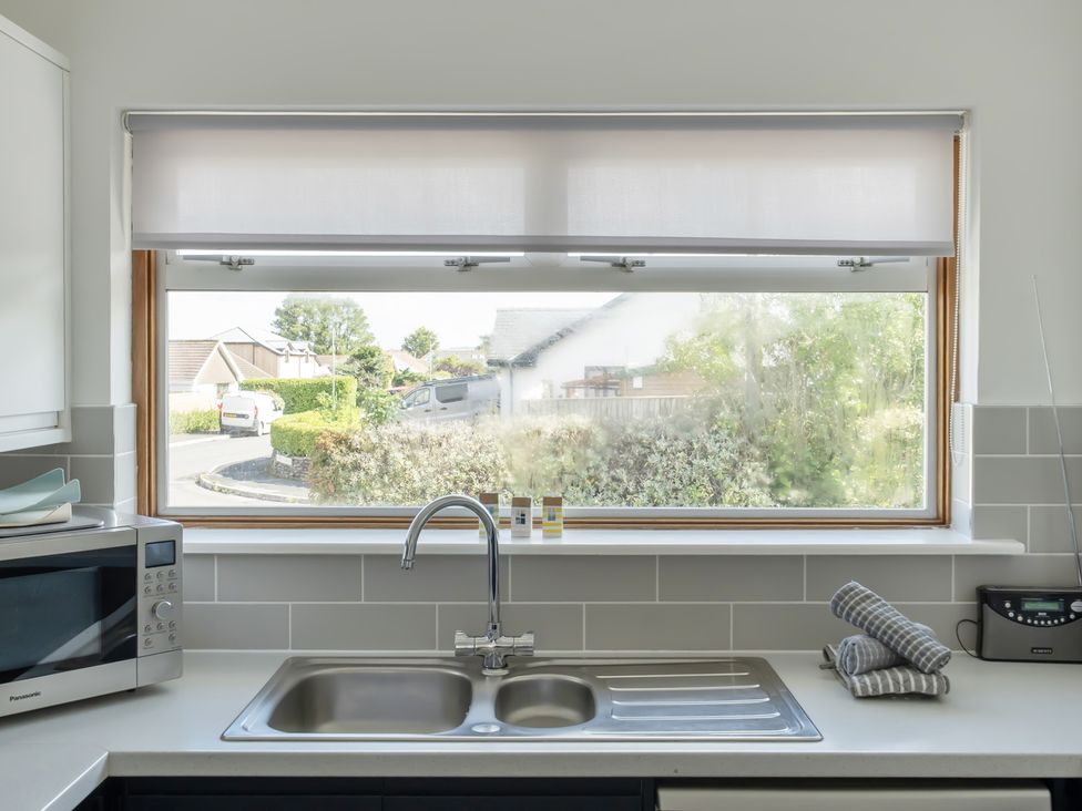 A kitchen with a sink and window at Sleeps 9 KingBeds Family Friendly in Pityme near Penmayne