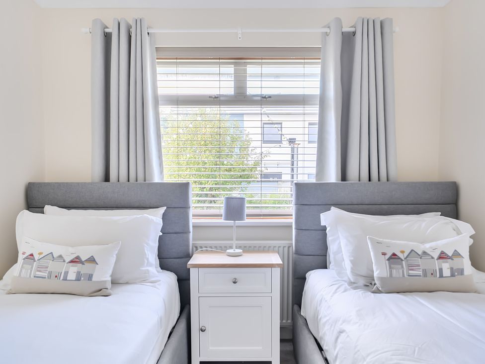 A bedroom with two beds and a bedside table at Sleeps 9 KingBeds Family Friendly in Pityme near Penmayne
