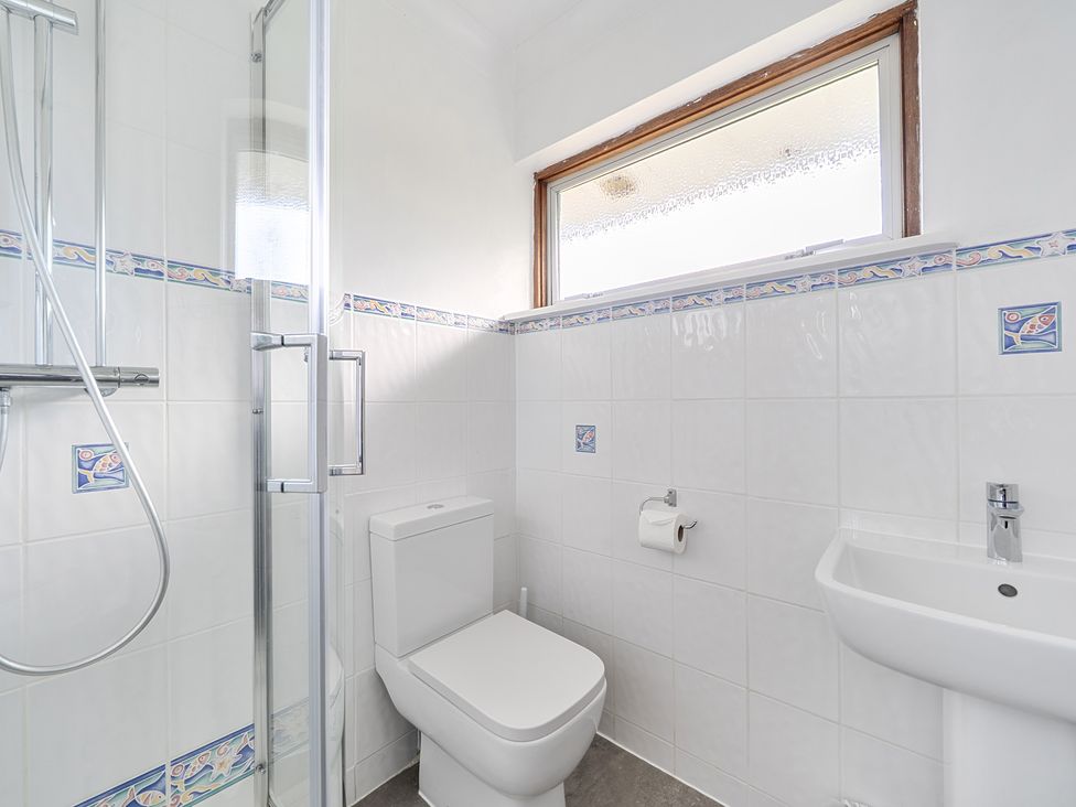 A bathroom with shower, toilet, and sink at Sleeps 9 KingBeds Family Friendly in Pityme near Penmayne