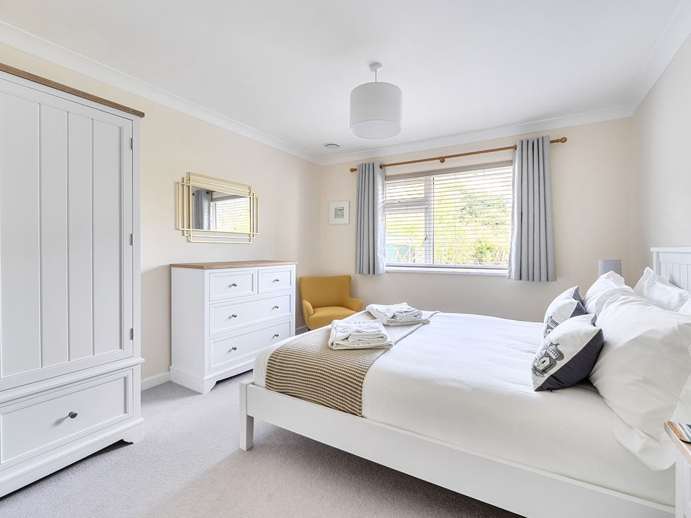 A bedroom with a bed and dresser at Sleeps 9 KingBeds Family Friendly in Pityme near Penmayne