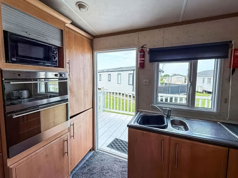 A kitchen with oven and microwave at Super 2 bed 6 berth caravan pets go free Hunstanton