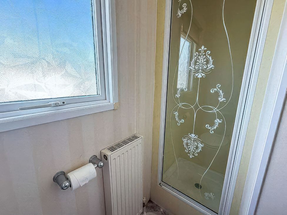A bathroom with a shower and a radiator at Super 2 bed 6 berth caravan pets go free Hunstanton