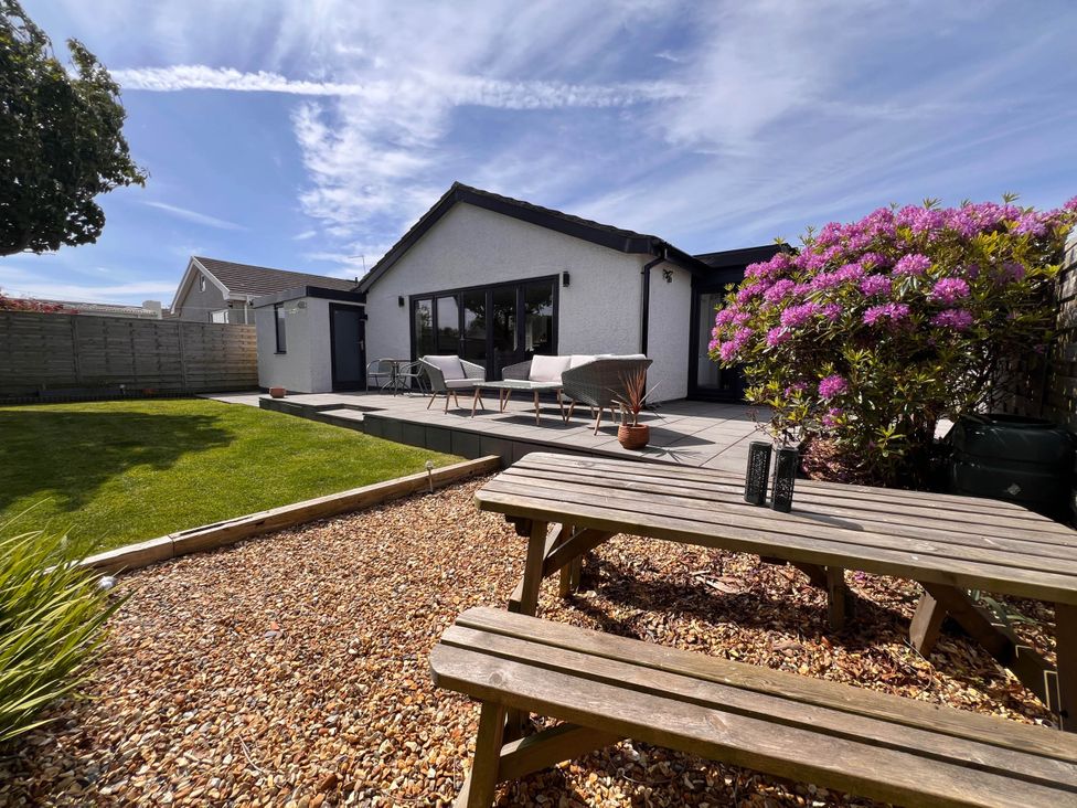 A garden with a house and patio seating at The Old Barn in Manchester