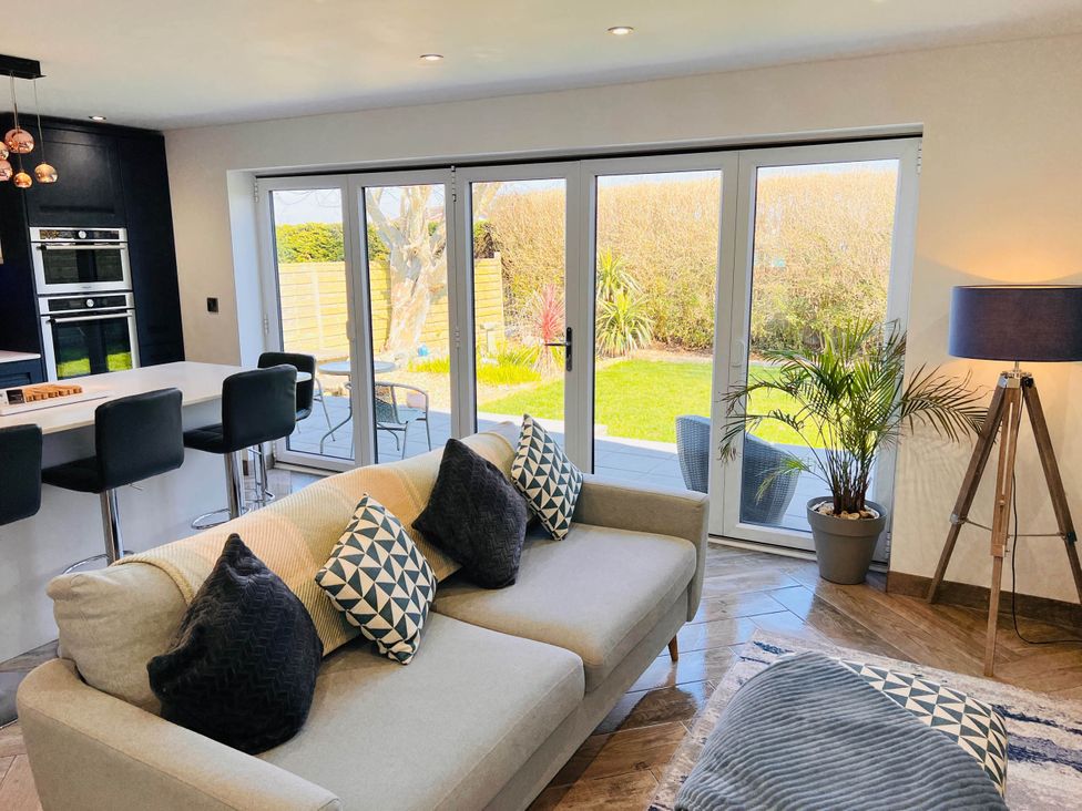 A living room with a sofa and kitchen bar stools at The Old Barn in Manchester