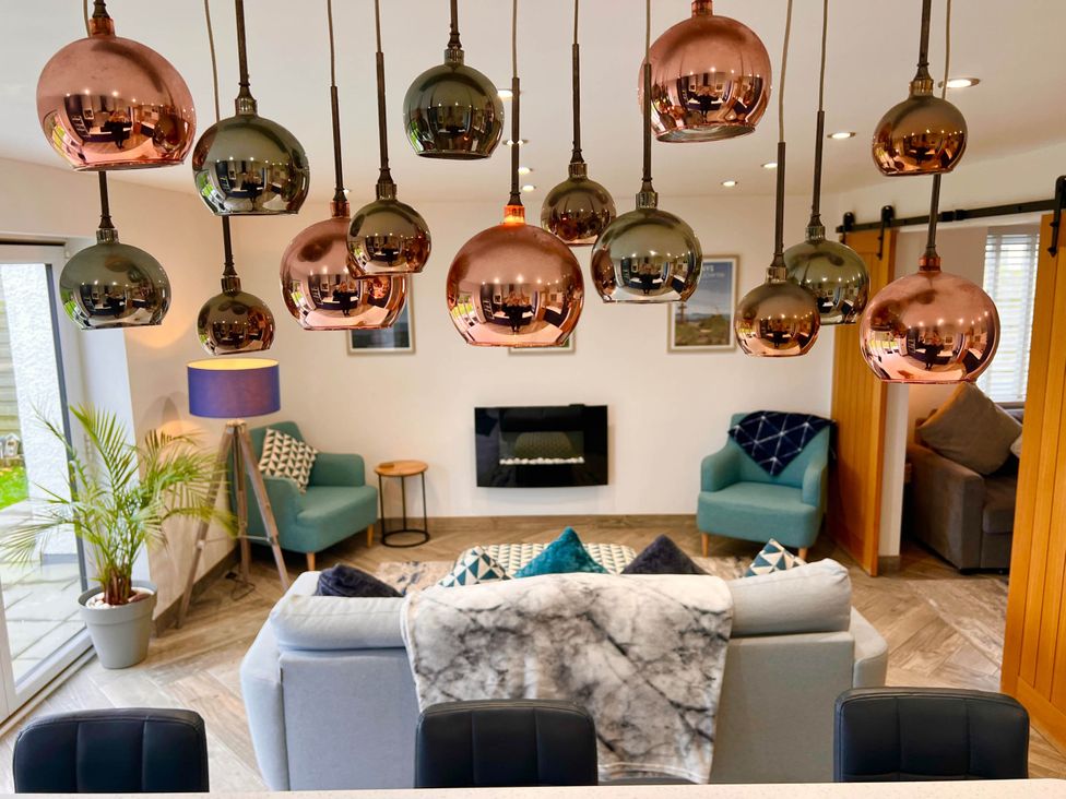 A living room with pendant lights and a fireplace