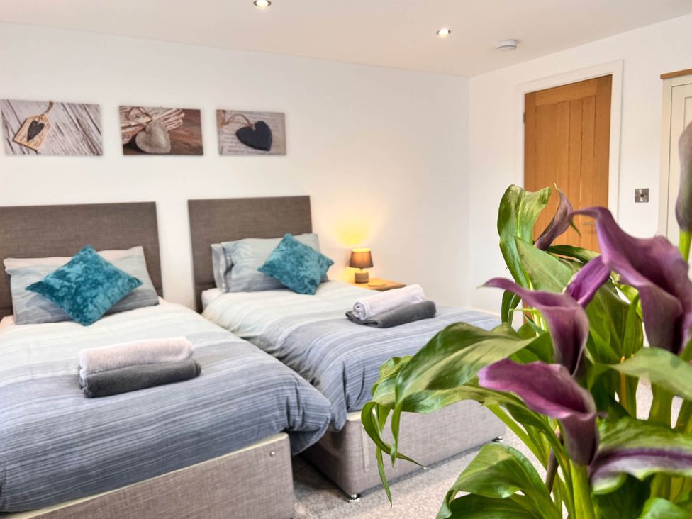 A bedroom with two beds, pillows, and a plant at the property