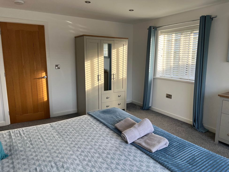 A bedroom with a bed and wardrobe at The Old Barn in Manchester