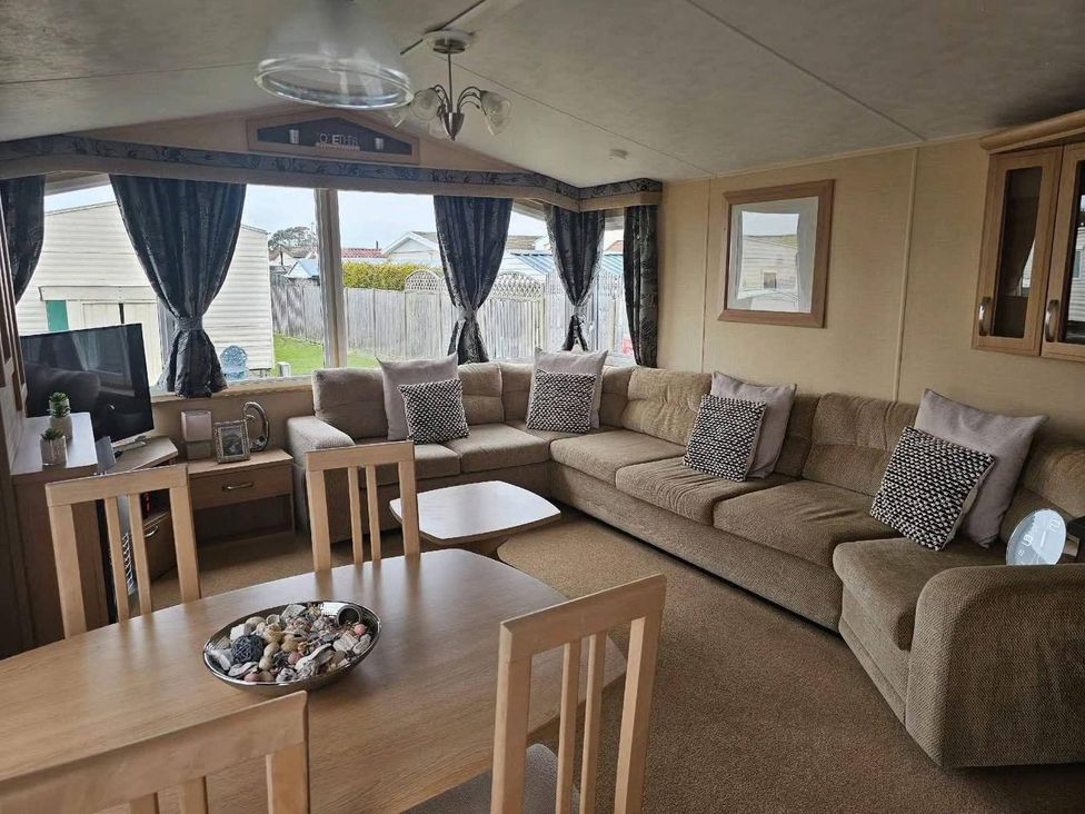 A living room with a sofa and coffee table at a holiday home in an outdoor setting