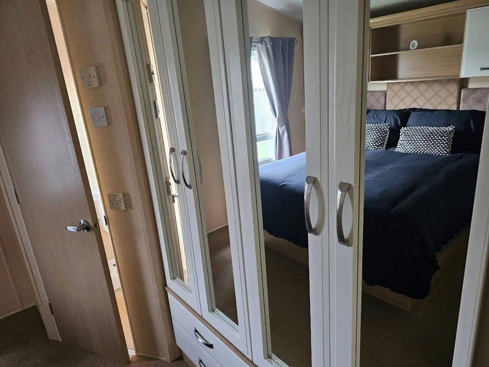 A bedroom with a bed and mirrors at the property in location