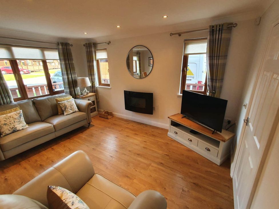 A living room with a sofa and television at Stunning 2 Bedroom Pet Friendly Lodge in Bridlington