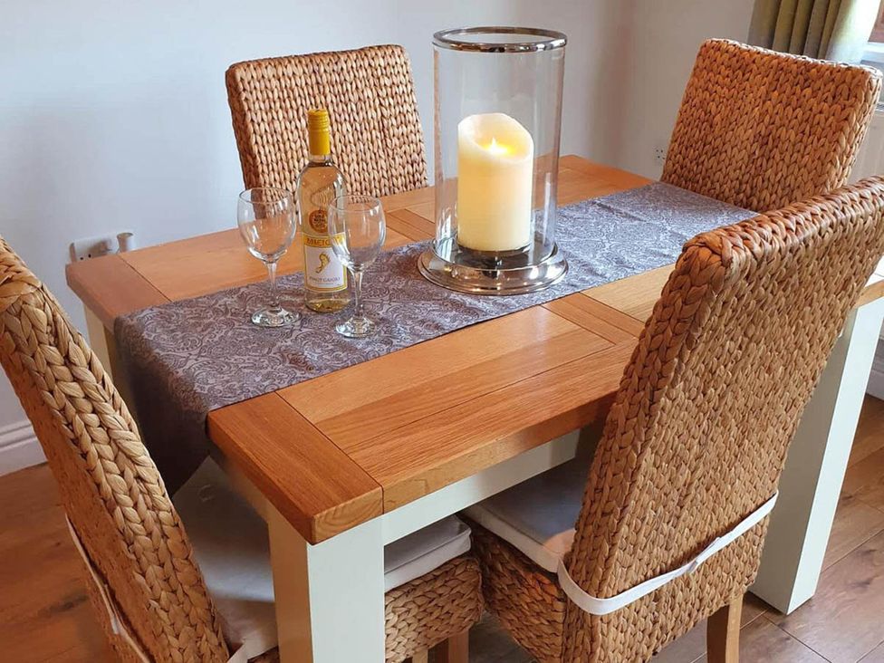 A dining table with a wine bottle and glasses at Stunning 2 Bedroom Pet Friendly Lodge in Bridlington