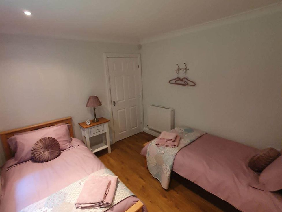 A bedroom with two beds and a small table at Stunning 2 Bedroom Pet Friendly Lodge in Bridlington