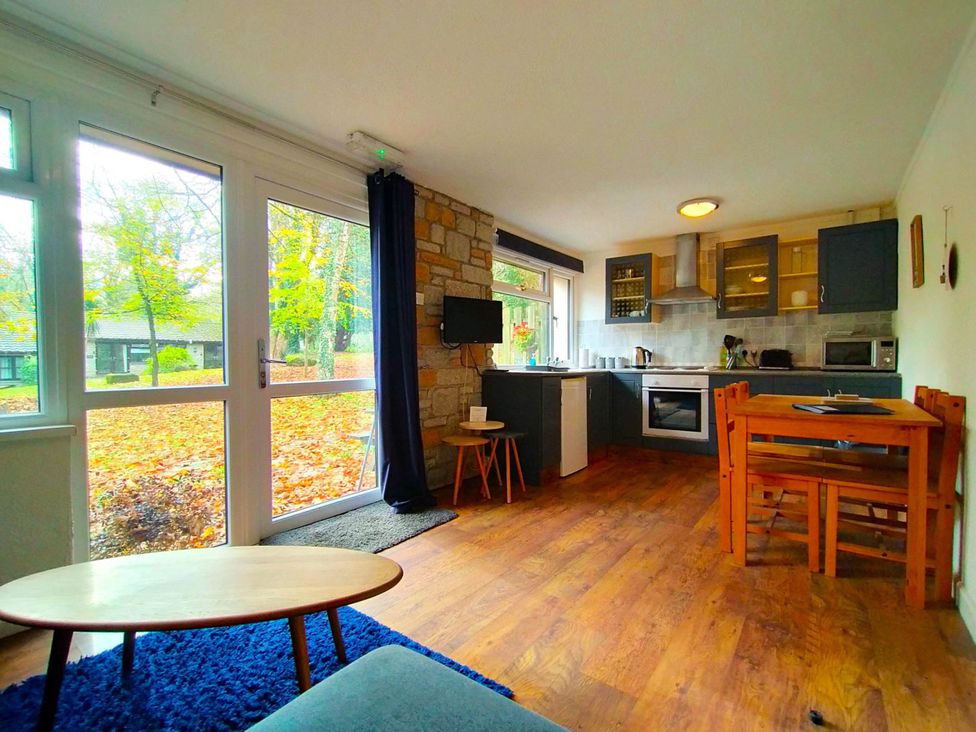 A kitchen with a dining table and chair at Painters Cottage 2Bed Chalet Free Leisure Passes Near St Ives