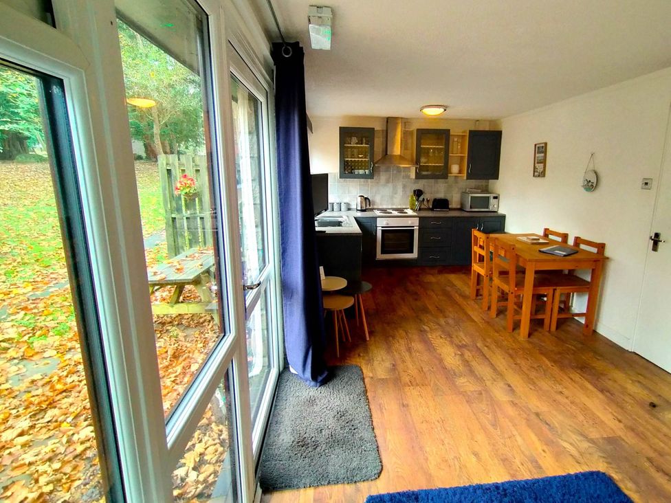 A kitchen with a table and chairs at Painters Cottage 2Bed Chalet Free Leisure Passes Near St Ives
