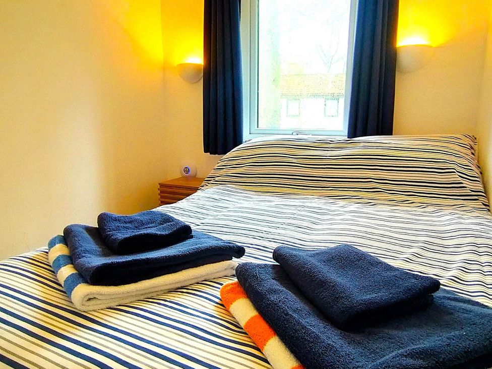 A bedroom with a bed and towels on it at Painters Cottage 2Bed Chalet Free Leisure Passes Near St Ives
